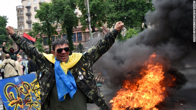 A protester from Kiev's Independence Square gestures May 31 as fellow protesters burn tires to protect their barricades from being dismantled by communal services.