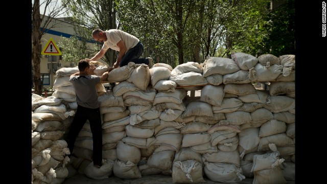 People pile up sandbags to set up a shooting position on the road leading from the Donetsk airport on May 27. 