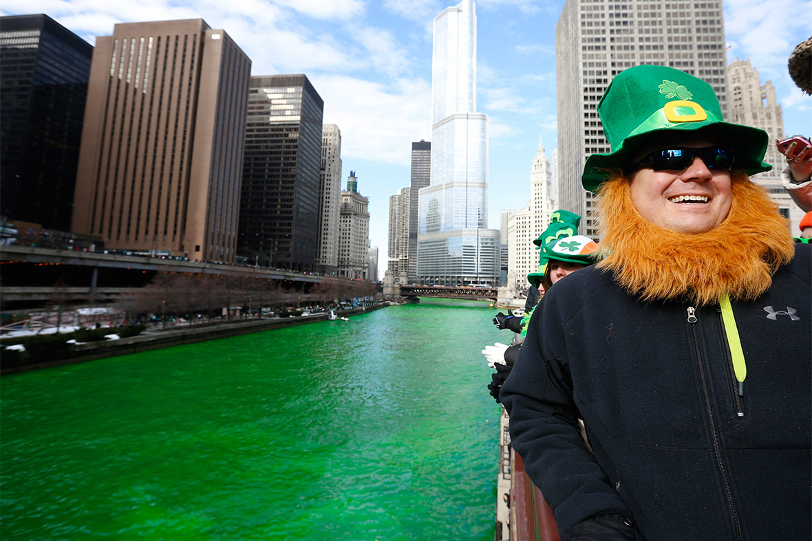 A man dressed as a leprechaun stands beside the Chicago River which was dyed green to celebrate St Patrick's Day