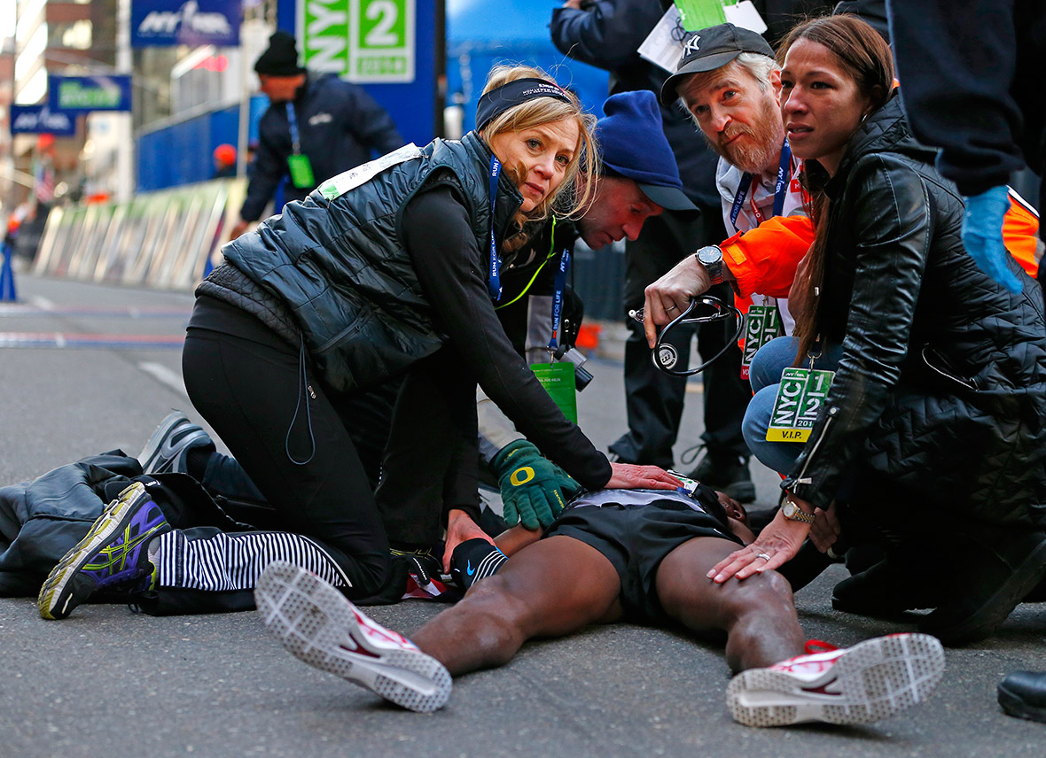 Mo Farah is treated by medical personnel after collapsing at the finish line at the 2014 New York City Half Marathon