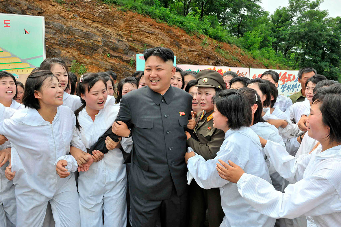 16 July 2013: The North Korean leader smiles as women flock around him at a mushroom farm