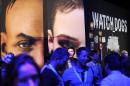 Attendees walk by the display for the Ubisoft game "Watch Dogs" at the E3 video game trade show in Los Angeles on June 12, 2013