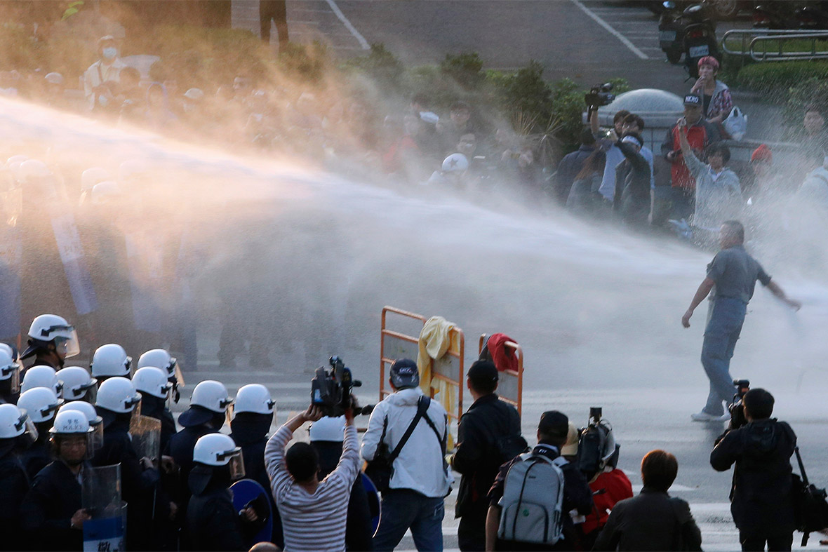 March 24, 2014: Police use a water cannon to disperse demonstrators during a protest against a trade pact with mainland China