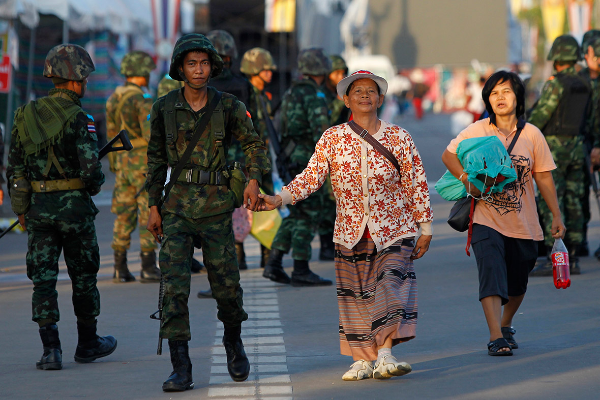 A Thai soldier holds hands with a member of the pro-government 