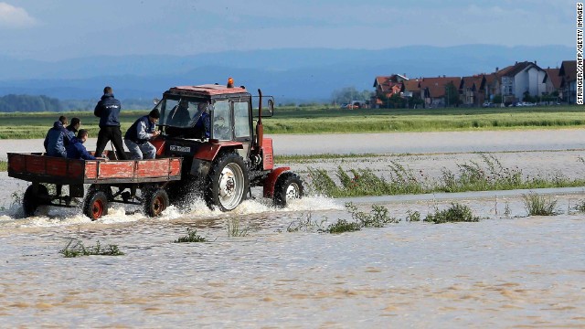 Residents ride in a wagon pulled by a tractor through a flooded field in the eastern Bosnian town of Bijeljina on May 17. Heavy rainfall in Serbia and neighboring Bosnia has resulted in the worst flooding the countries have seen since records began 120 years ago, meteorologists say.