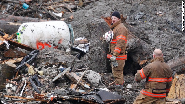 Searchers in Oso pause for a moment of silence on Saturday, March 29. It was observed at 10:37 a.m., exactly one week after the landslide tore through the small community.