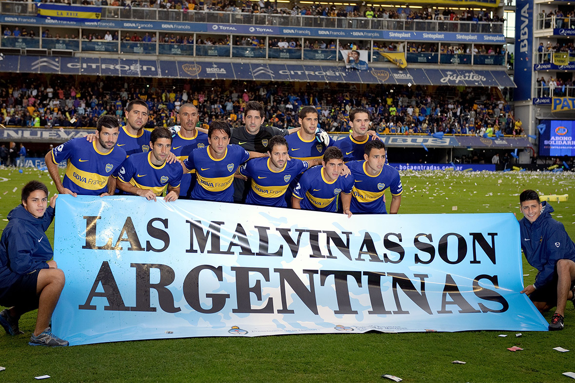 Boca Juniors players pose with a protest banner before their Argentine first division football match against River Plate in Buenos Aires