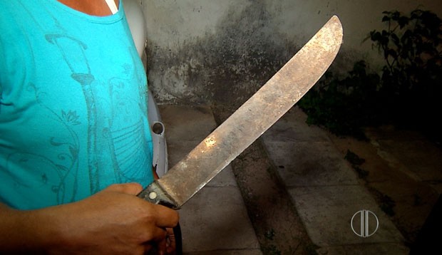 Filha, que também sofreu abuso sexual, segura o facão que foi usado pelo criminoso para ameaçá-la (Foto: Reprodução/Inter TV Cabugi)