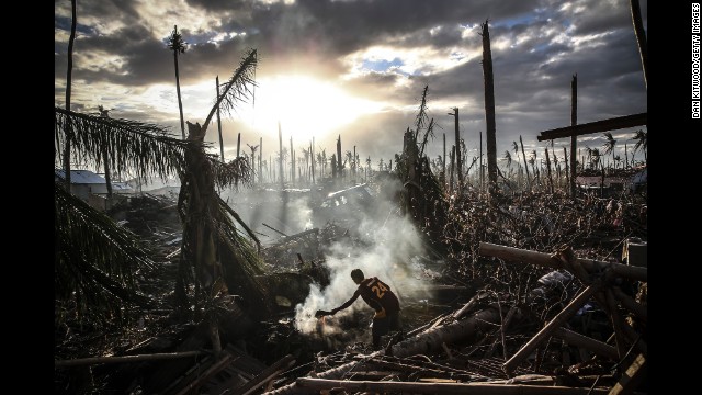 A man fans flames on a fire in Leyte, Philippines, after Typhoon Haiyan ripped through the country in November.