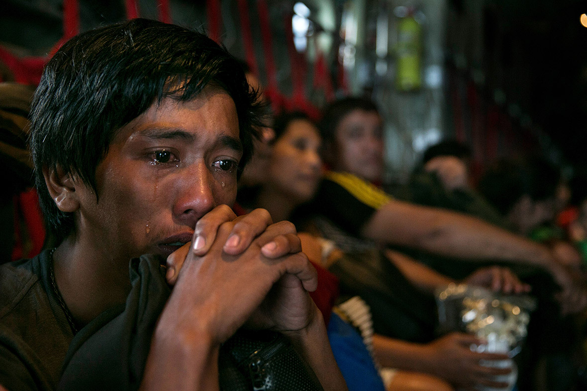 November 12, 2013: A man cries on a packed C130 aircraft as he and hundreds of other survivors of super typhoon Haiyan are evacuated from Tacloban
