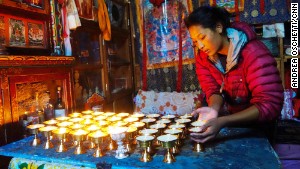 Ang Tshiring\'s daughter, Nima, attends to butter lamps in the prayer room.