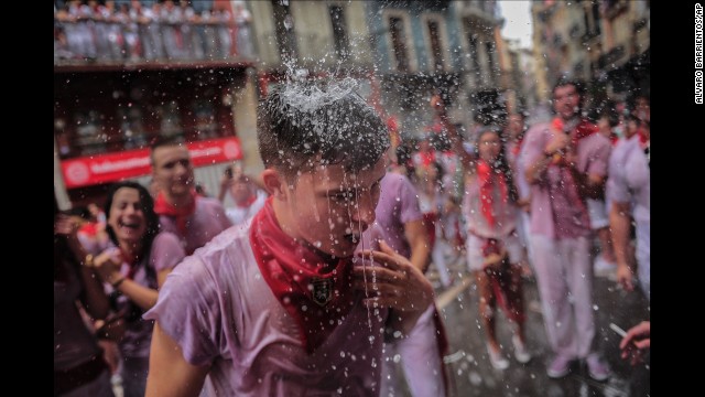 Revelers have water thrown on them from a balcony to celebrate the official opening of the San Fermin festivities on Sunday, July 6. 