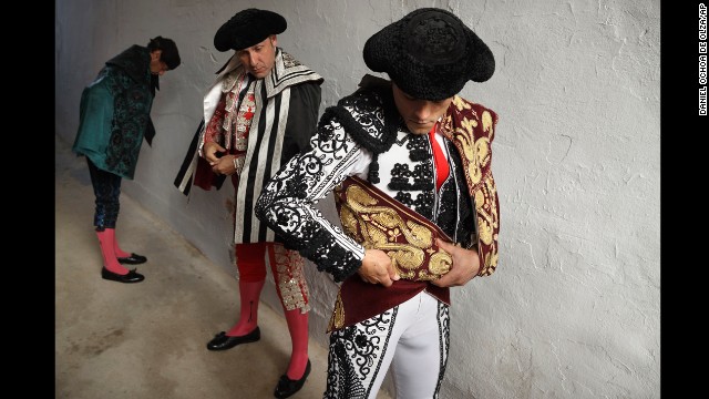 Bullfighter Miguel Abellan adjusts his capote before the ritual entrance to the arena on July 7.