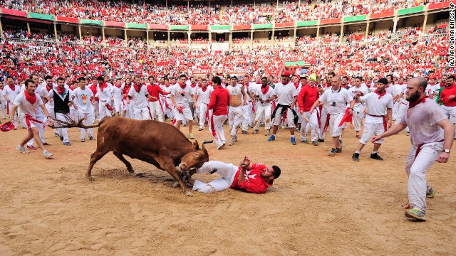 A reveler is pushed by a bull in the bull ring on Tuesday, July 8.