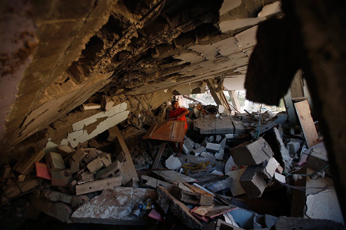 A Palestinian searches for his belongings under the rubble of a house destroyed in an Israeli air strike in the northern Gaza Strip