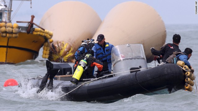 Divers jump into the water on April 21 to search for passengers near the buoys which mark the site of the sunken ferry.