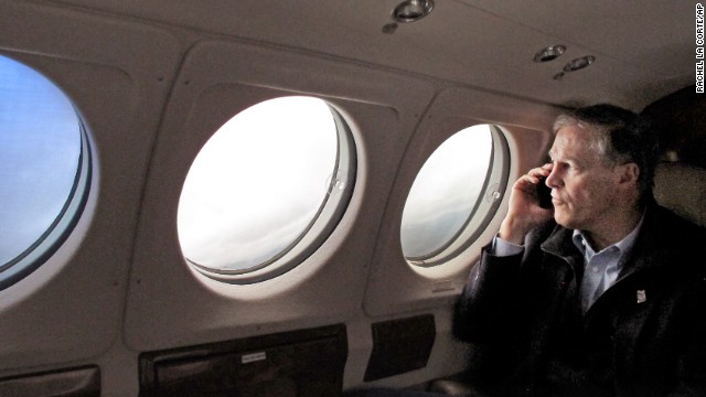 Washington Gov. Jay Inslee speaks on the phone with a victim's family member as he flies to the Snohomish County Emergency Operations Center in Everett, Washington, on March 26.