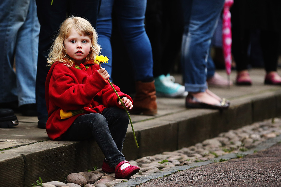 Abigail Smith, aged 4, holds a yellow flower as she waits for the funeral cortege of Stephen Sutton to pass by on its way to Lichfield Cathedral