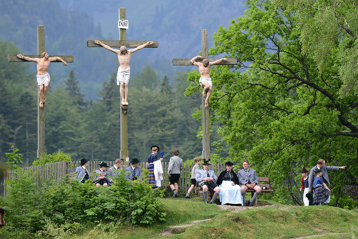 Pilgrims in traditional Bavarian folk costumes stand beneath three crosses on the Kalvarienberg mountain in Birkenstein near Fischbachau, Germany to celebrate Ascension (in German called Christi Himmelfahrt)
