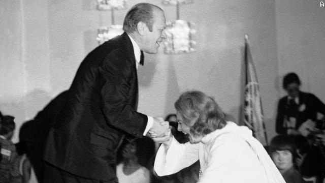 President Gerald Ford gives Walters a helping hand as she slips while stepping onto the stage in Washington during an awards presentation on March 10, 1975, for participants in the Special Olympics. 