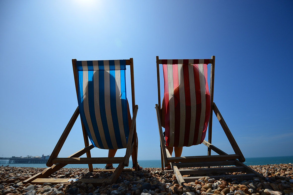 People relax in deck chairs on the beach in Brighton on the hottest day of the year so far.