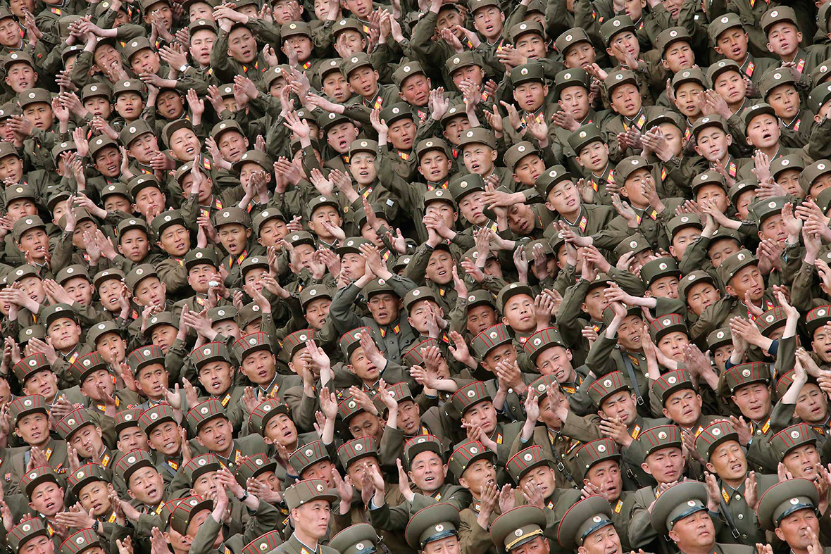 North Korean soldiers who took part in building a workers' hostel at the Kim Jong Suk Pyongyang Textile Mill applaud during a photo session with the country's leader Kim Jong-un.