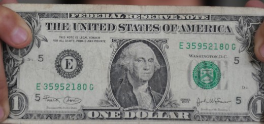 A person holds a one dollar bill on Dece