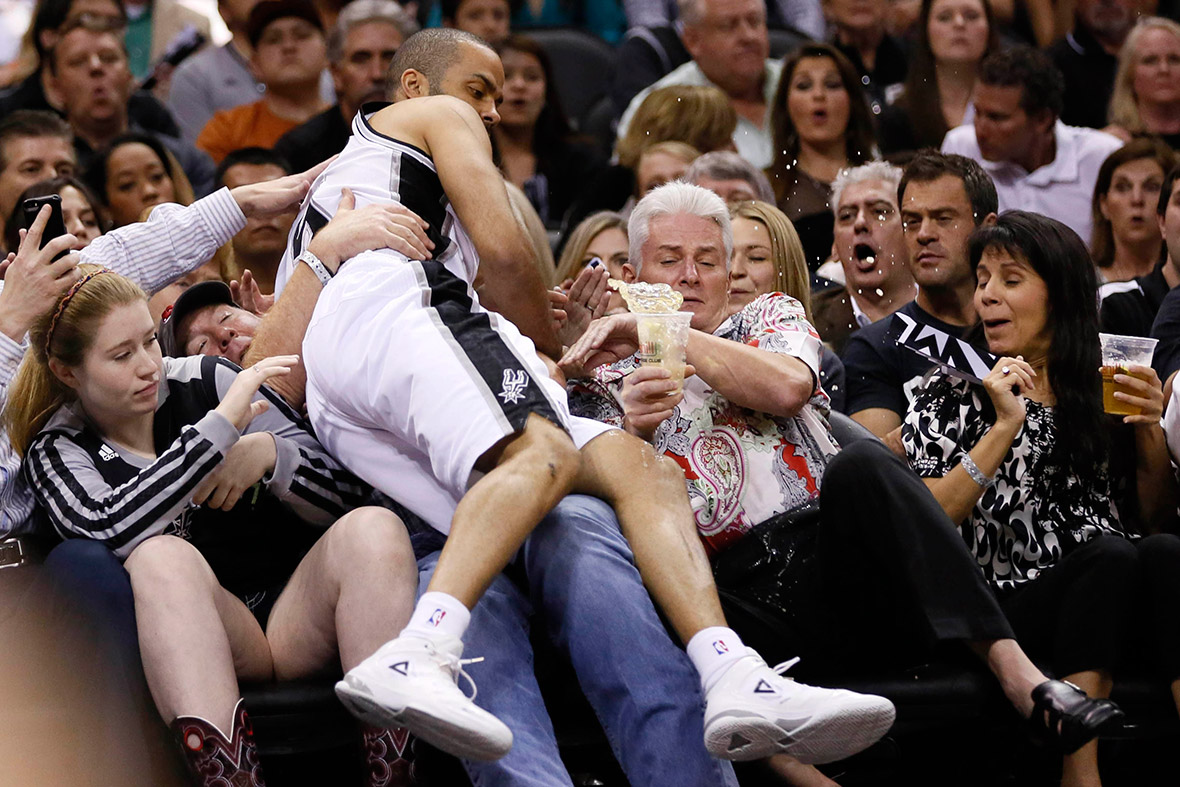 San Antonio Spurs guard Tony Parker lands on a fan during the second round of the 2014 NBA Playoffs against the Portland Trail Blazers