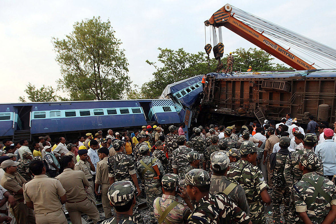 Security personnel and rescue workers gather around damaged coaches of a passenger train after a collision in Khalilabad in the northern Indian state of Uttar Pradesh. A passenger train collided with a stationary goods train, killing at least 40 people and injuring more than 150