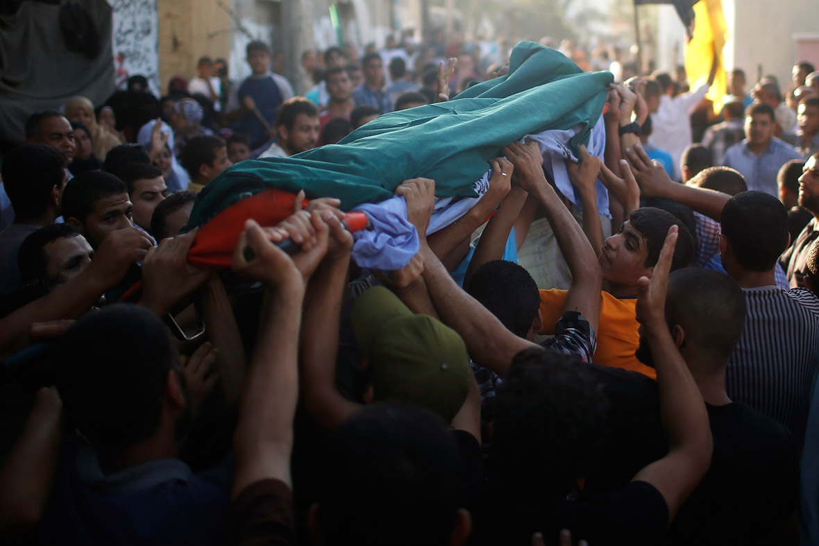 Mourners carry the body of Palestinian militant Osama al-Hosomi during his funeral in the northern Gaza Strip on 27 June. An Israeli air strike killed two Palestinian militants and critically wounded a third. A source identified the men as belonging to the Popular Resistance Committees, a network of militant groups that has fired rockets into southern Israel