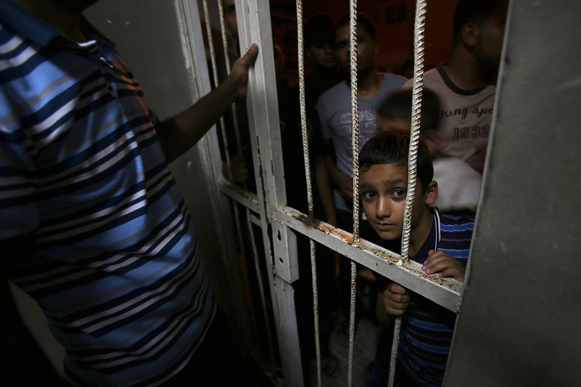 A Palestinian boy looks at the body of a Hamas gunman at a hospital morgue in Khan Younis in the southern Gaza Strip on 29 June