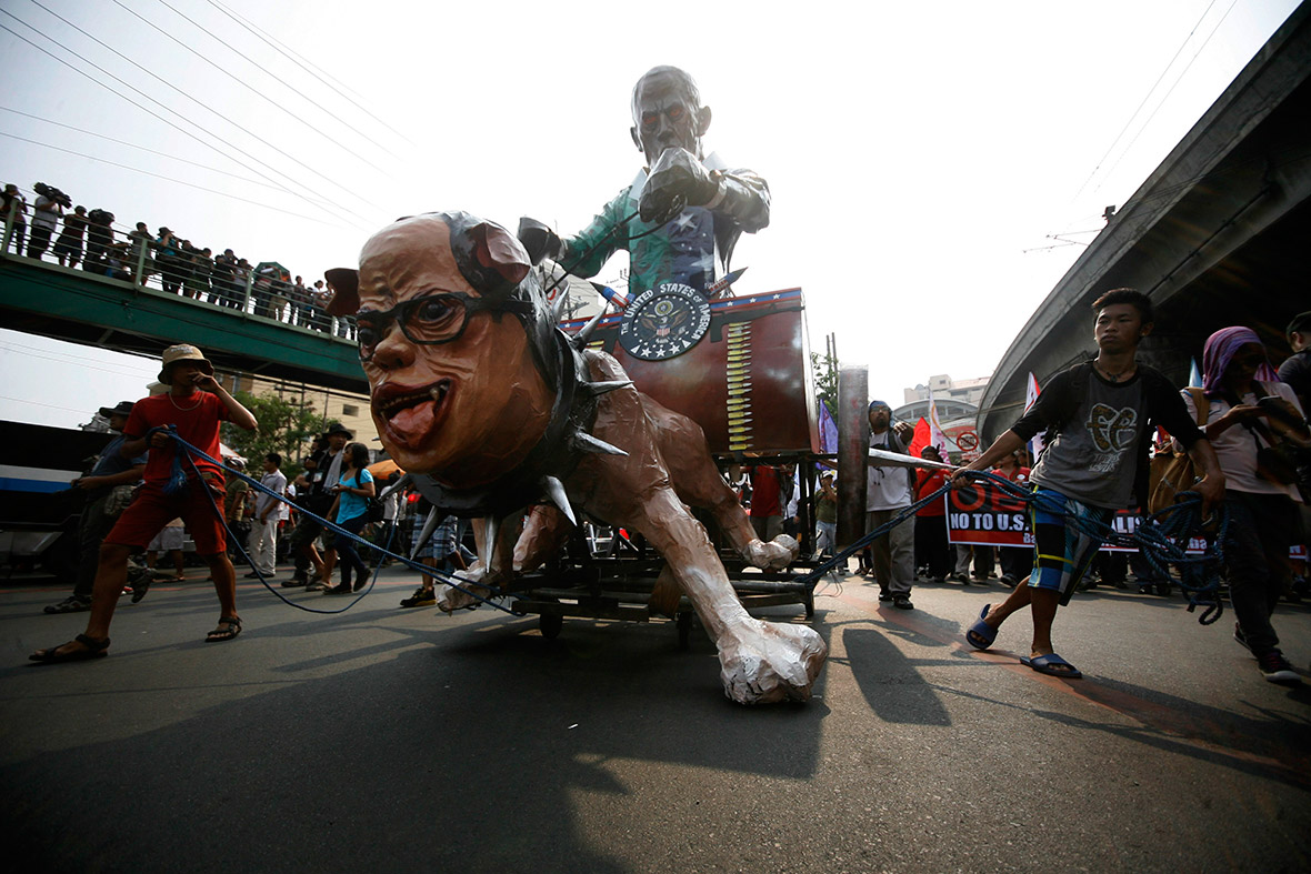 Activists drag an effigy of Barack Obama riding Philippine President Benigno Aquino along a main road towards the presidential palace in Manila.