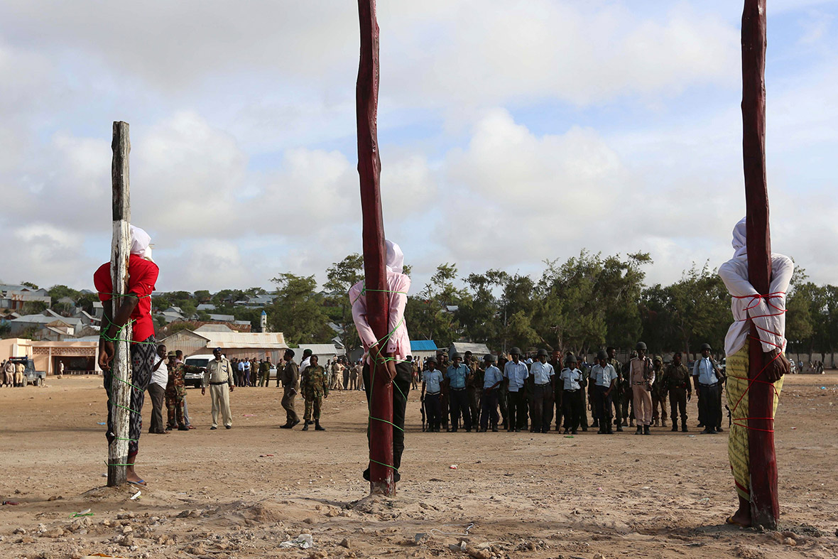 Three members of the militant group Al Shabaab, found guilty by a Somali military court of killing civilians and masterminding a recent attack on the Presidential Palace, stand tied to poles shortly before they were executed by a firing squad in Mogadishu