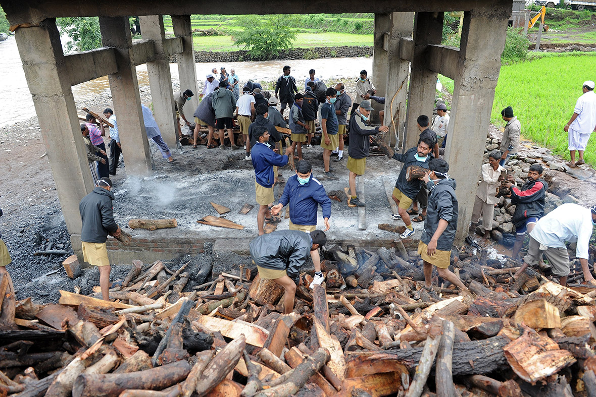 Volunteers prepare a funeral pyre for the mass cremation of landslide victims in Malin, Pune district in the western Indian state of Maharashtra