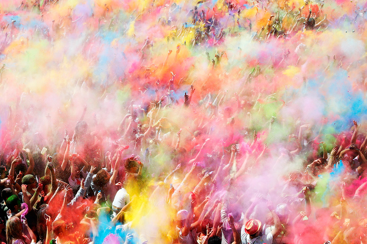 People throw coloured powder during Holi festival celebrations in Barcelona