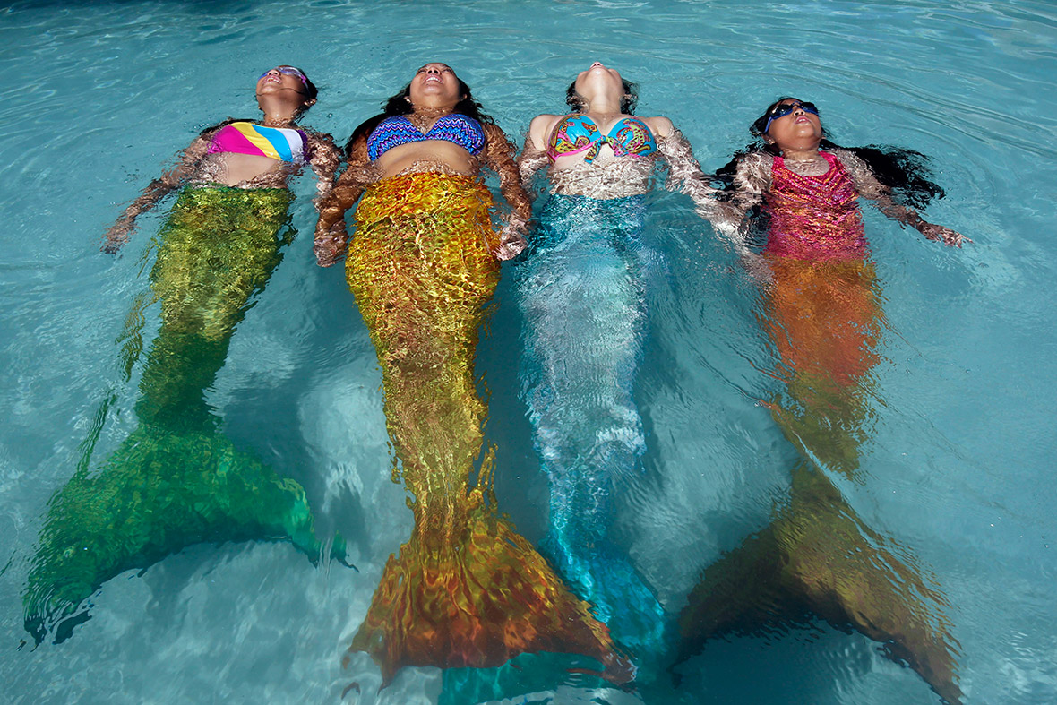 An instructor from the Philippine Mermaid Swimming Academy puts three trainee mermaids through their paces in a private pool in Paranaque city, metro Manila