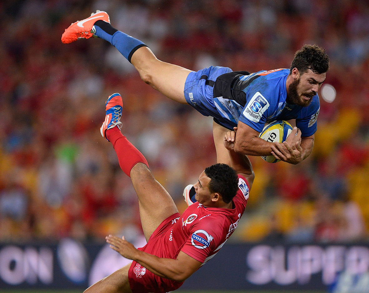 Jayden Hayward of the Force collides in midair with Jonah Placid of the Reds during their round eight Super Rugby match in Brisbane, Australia