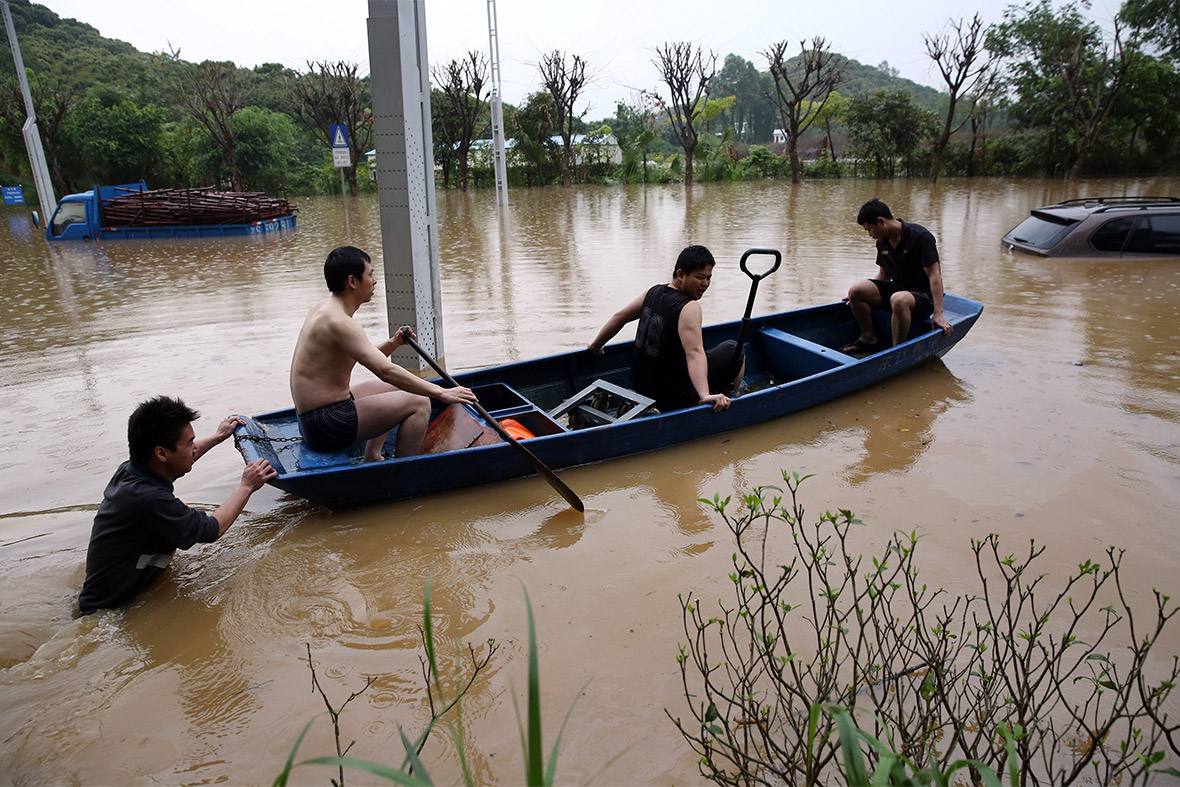 Residents use a boat on a flooded street in Dongguan, Guangdong Province, after a heavy rainstorm hit southern China
