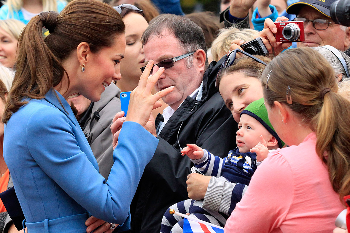 Kate greets a baby after laying a wreath with her husband at the war memorial in Blenheim