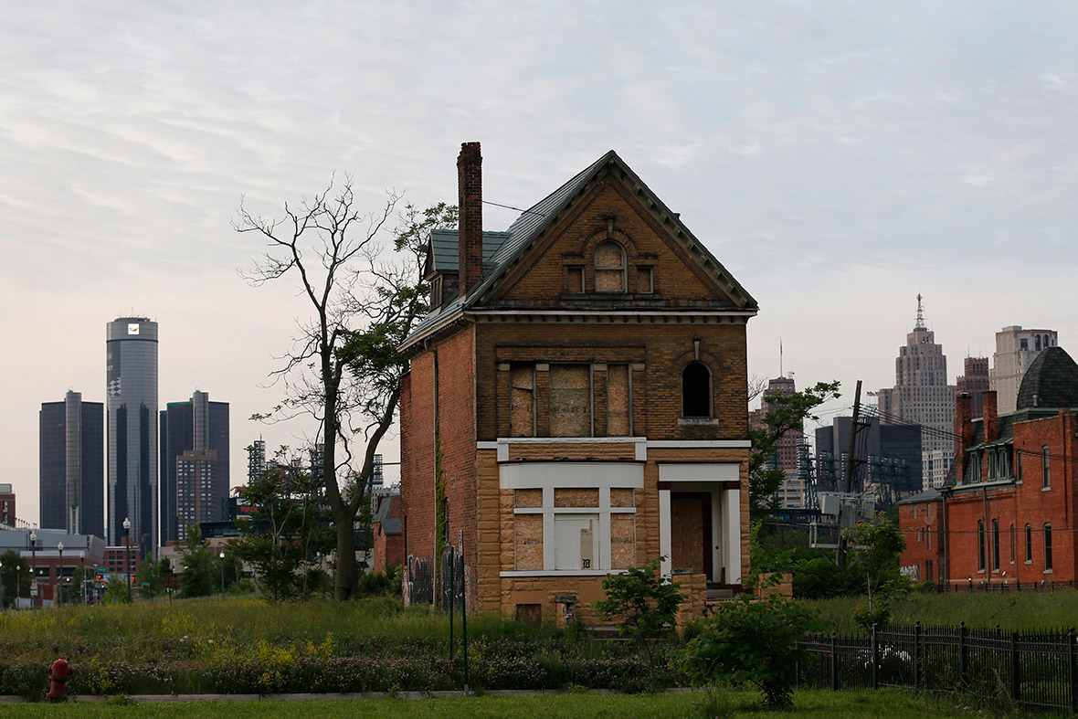 A boarded-up vacant home is seen in front of the General Motors headquarters in Detroit