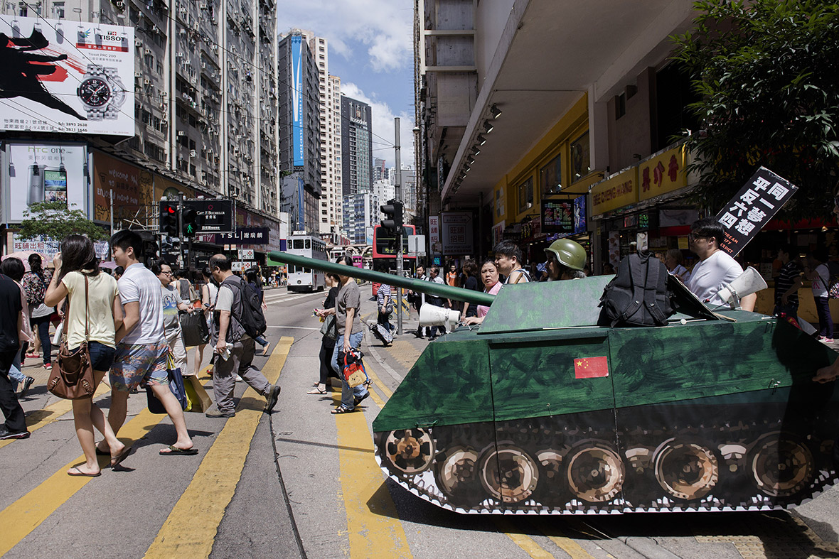 Activists push a replica of a Chinese tank across a street in Hong Kong to commemorate the 1989 Tiananmen Square military crackdown in Beijing