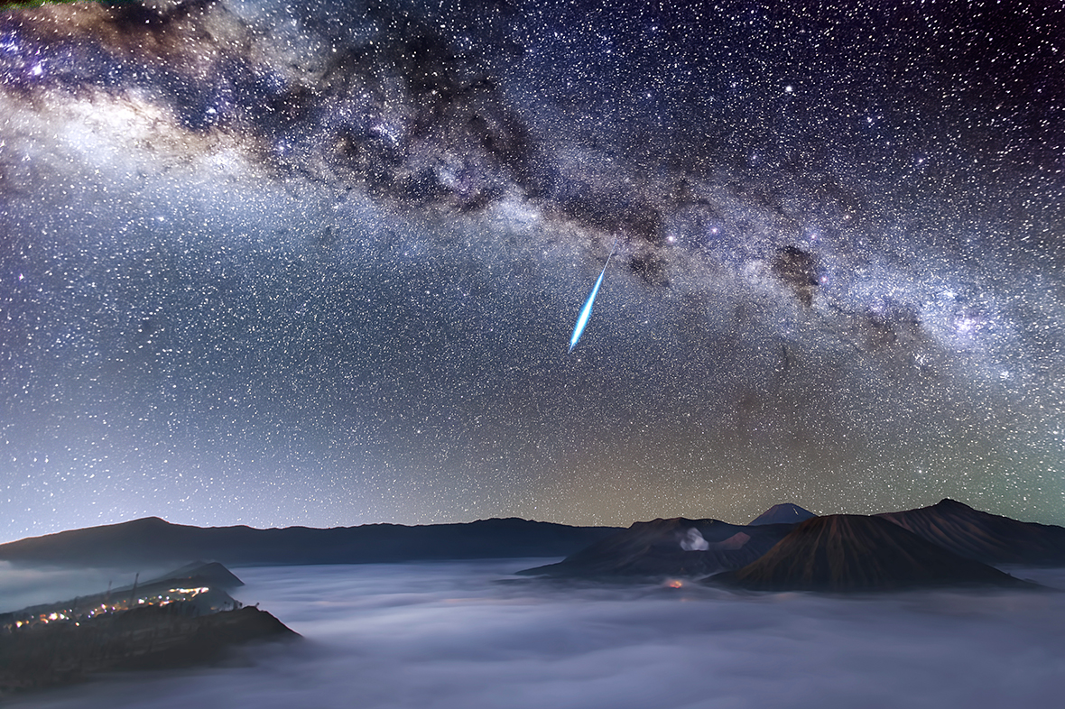 Eta Aquarid Meteor Shower over Mount Bromo by Justin Ng (Singapore). A bright meteor streaks across the magnificent night sky over the smoke-spewing Mount Bromo just one day before the peak of the Eta Aquarid meteor shower, which is caused by Halley's Comet. Mount Bromo is one of the most well-known active volcanoes in East Java, Indonesia. Also seen in the photograph are the highest active volcano, Mount Semeru (3676m), and the extinct volcano, Mount Batok, which is located to the right of Mount Bromo.