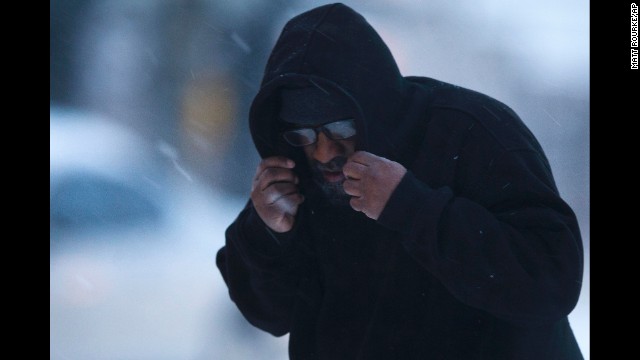 A man in Philadelphia shields his face from the elements February 13.