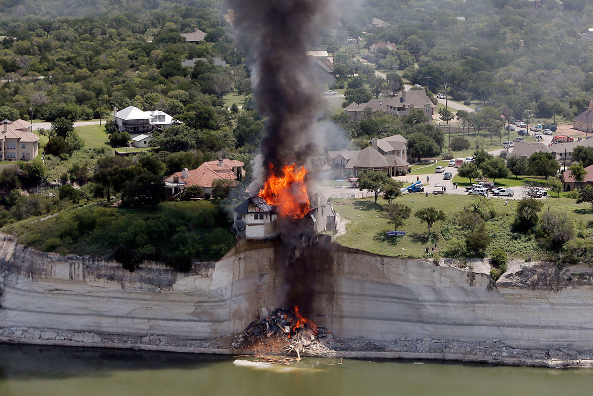 A house is deliberately set on fire, after part of the ground it was resting on collapsed into Lake Whitney, Texas
