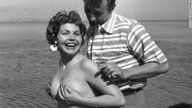 Starlet Simone Silva poses topless with idol Robert Mitchum in 1954.