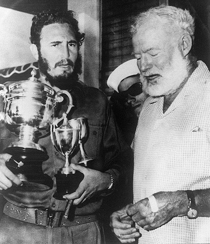 1960: US writer Ernest Hemingway awards three trophies to Castro after a fishing contest in Cuba.