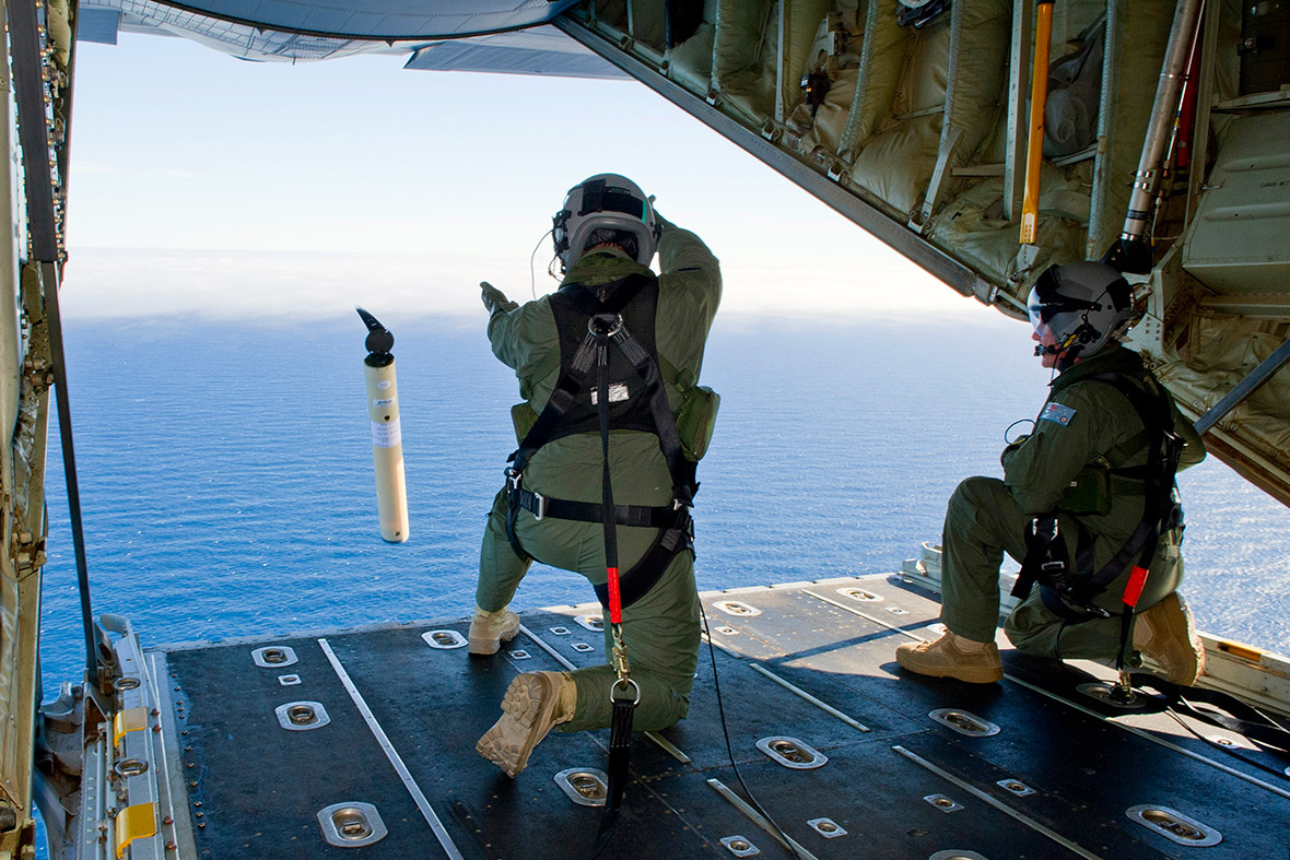 Royal Australian Air Force Loadmasters, Sergeant Adam Roberts and Flight Sergeant John Mancey, launch a 'Self Locating Data Marker Buoy' from a C-130J Hercules aircraft in the southern Indian Ocean during the search for missing Malaysian Airlines flight MH370