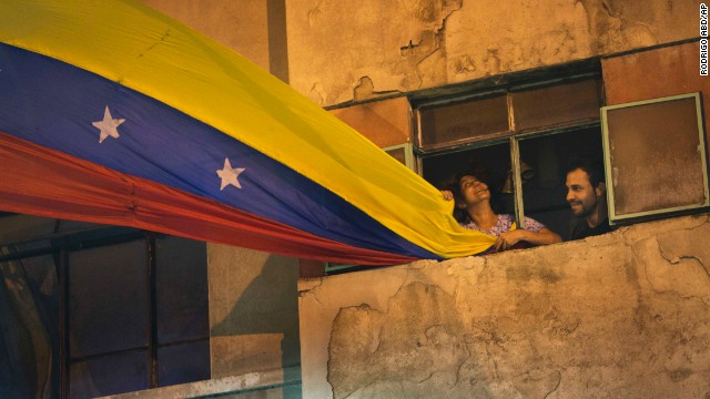 A woman waves a Venezuelan flag out of her window on February 21 in Caracas.