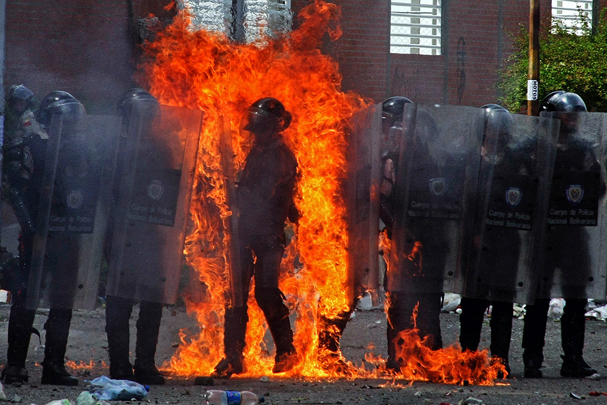 A riot policeman is engulfed in flames as a molotov cocktail is thrown by a protester in San Cristobal, Venezuela