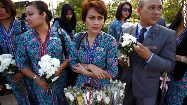 Malaysia Airlines' crew members held flowers as they waited for the plane's arrival. MH17 was shot down over eastern Ukraine on July 22, killing all 298 people on board.